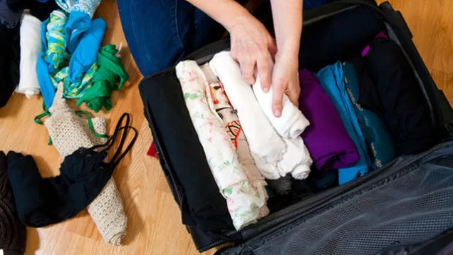 a woman packing clothes. The complete packing guide for visitors to Nigeria